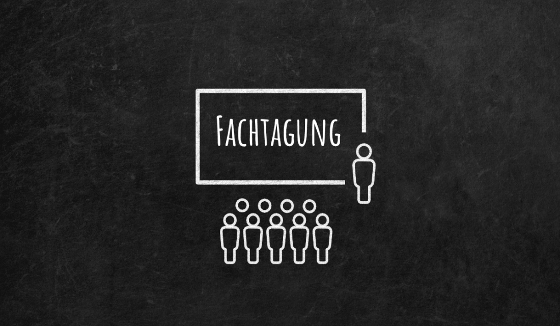 Schwarze Tafel mit einer Kreidezeichnung von Menschen vor einer Leinwand auf der Fachtagung steht.