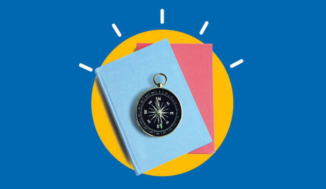 zwei Bücher in blau und rosa auf denen ein Kompass liegt