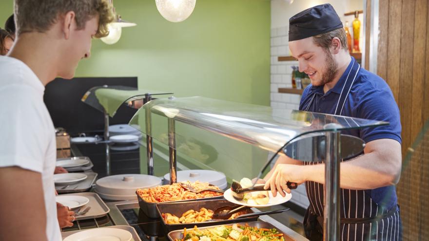 Koch portioniert Essen auf Teller