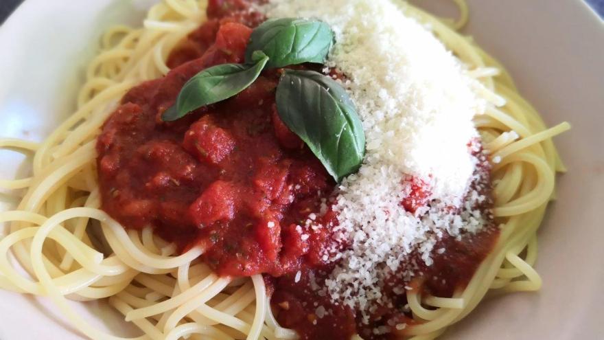 Spaghetti mit Tomatensoße und Parmesan auf einem Teller.