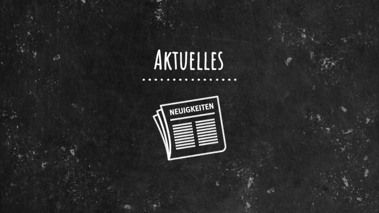 Schwarze Tafel mit Schriftzug Aktuelles und Kreidebild einer Zeitung